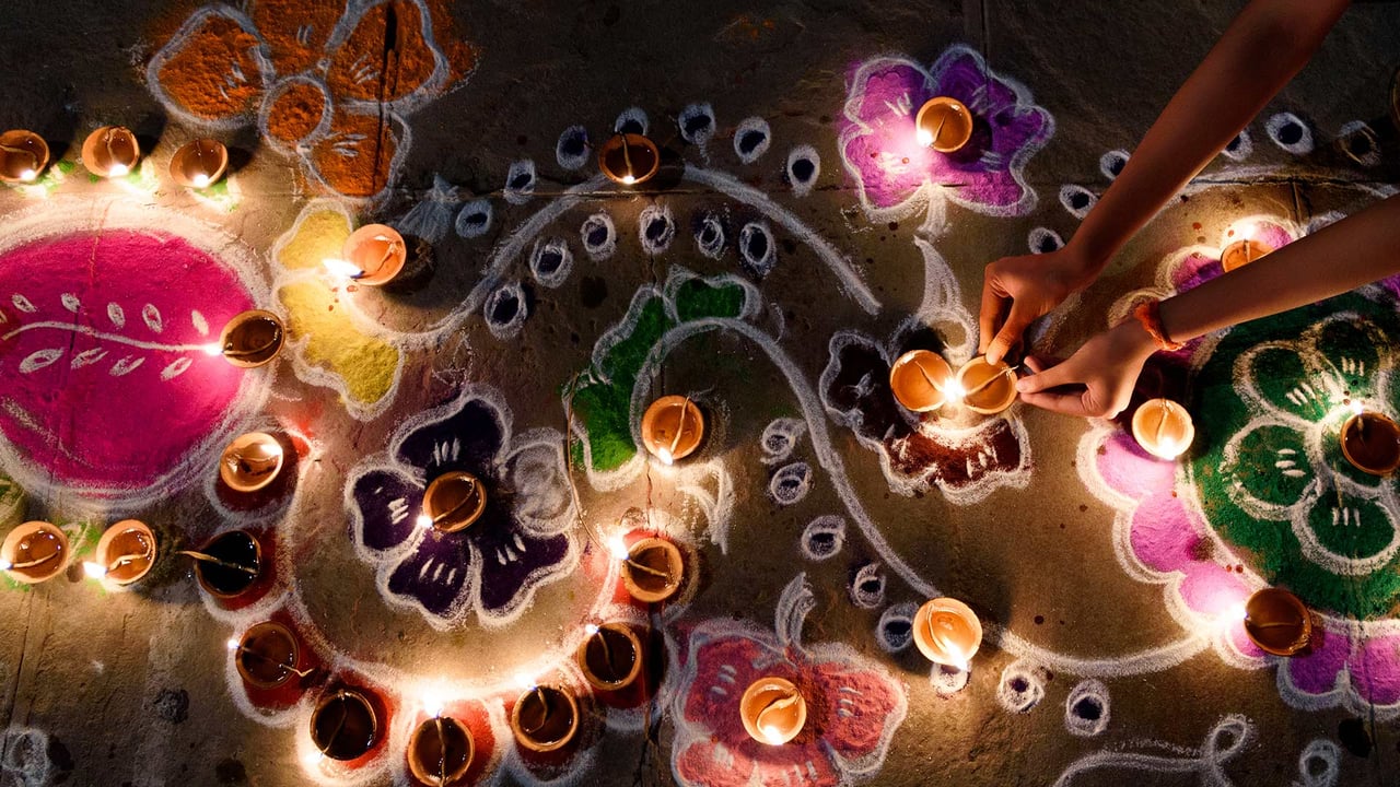 Oil lamps being arranged on rangoli designs during Diwali (© Subir Basak/Getty Images)