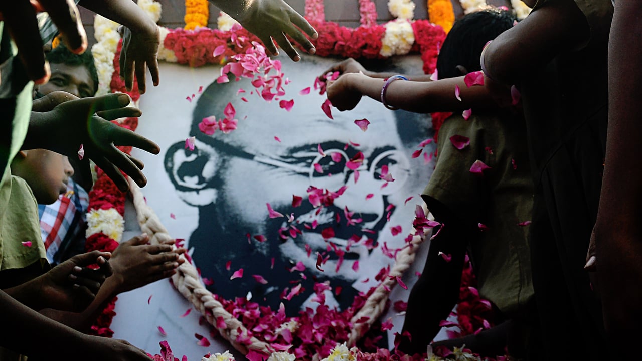 School children pay homage to a portrait of Mahatma Gandhi on Martyr's Day. (© ARUN SANKAR/AFP via Getty Images)