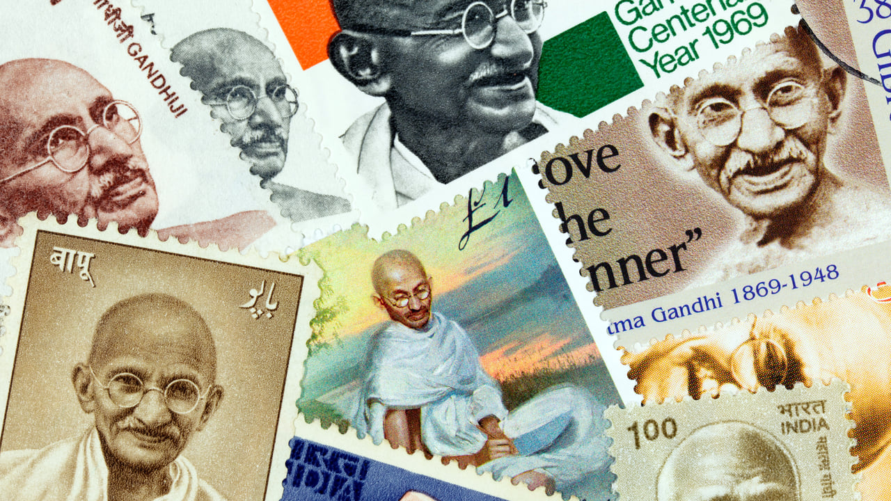 An assortment of postage stamps with images of Mahatma Gandhi (© PictureLake/E+/Getty Images)