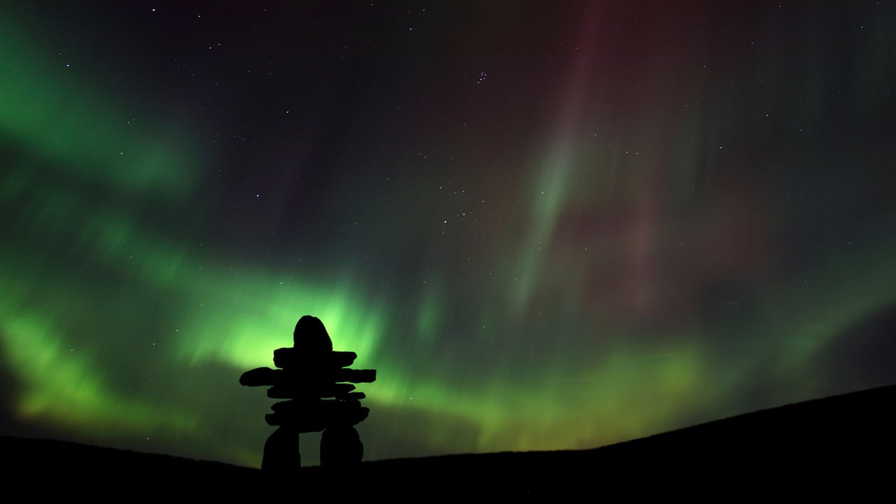 Inukshuk silhouetted against the Northern Lights in Barren Lands, Northwest Territories, Canada (© Mark Duffy/Alamy)