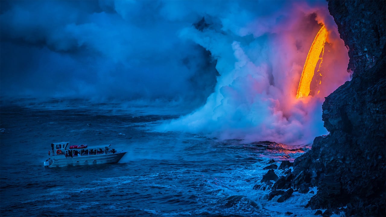 A lava flow hits water as a tour boat passes, Hawaii Volcanoes National Park (© Patrick Kelley/Getty Images)