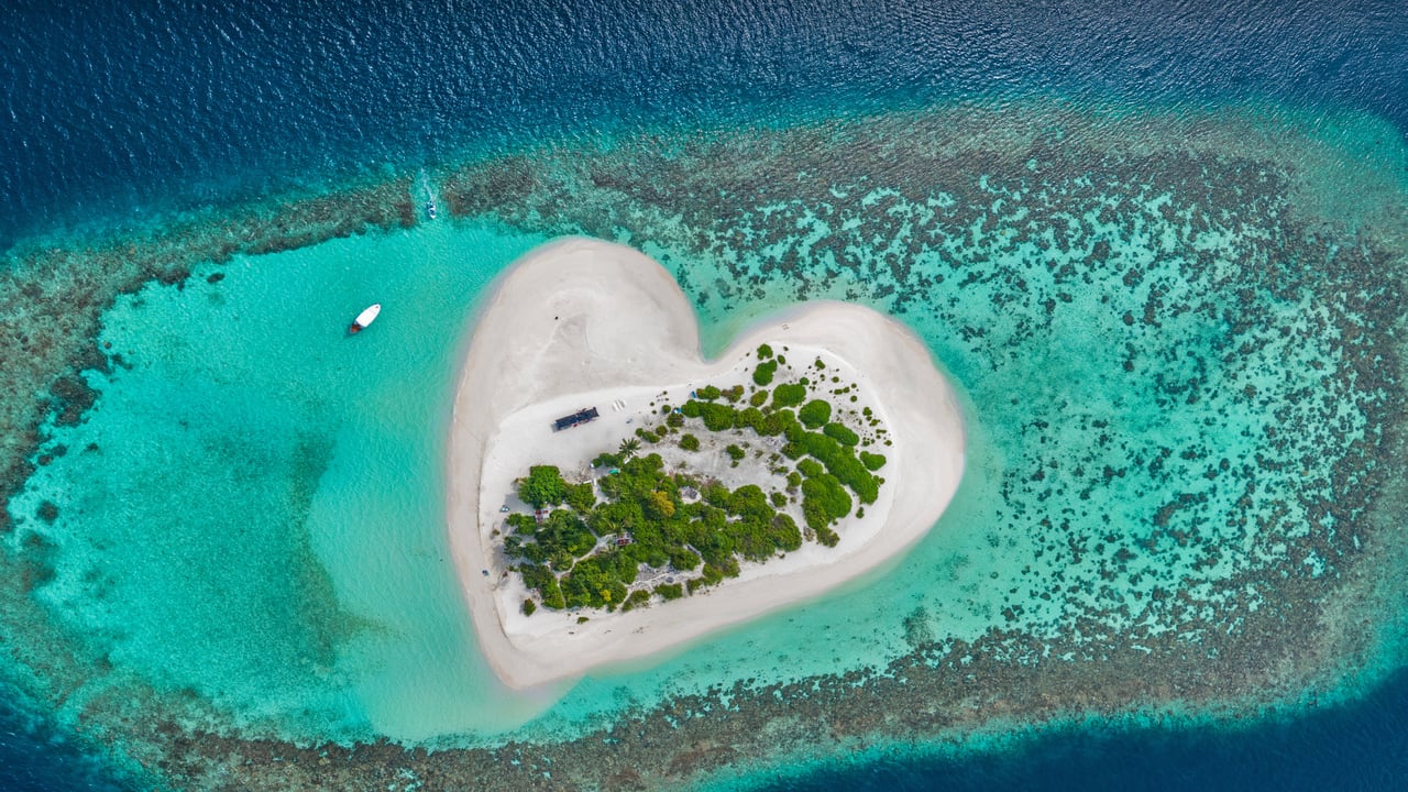 Heart-shaped island with sandy beach, offshore coral reef, Indian Ocean, Maldives (© Willyam Bradberry/Shutterstock)