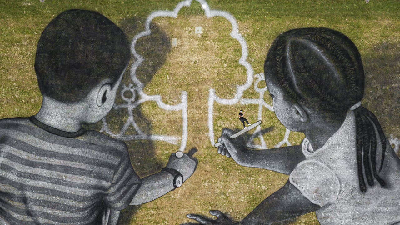 L’artiste Saype avec son œuvre de land art au siège de l’ONU, Genève, Suisse (© Valentin Flauraud/EPA-EFE/Shutterstock)