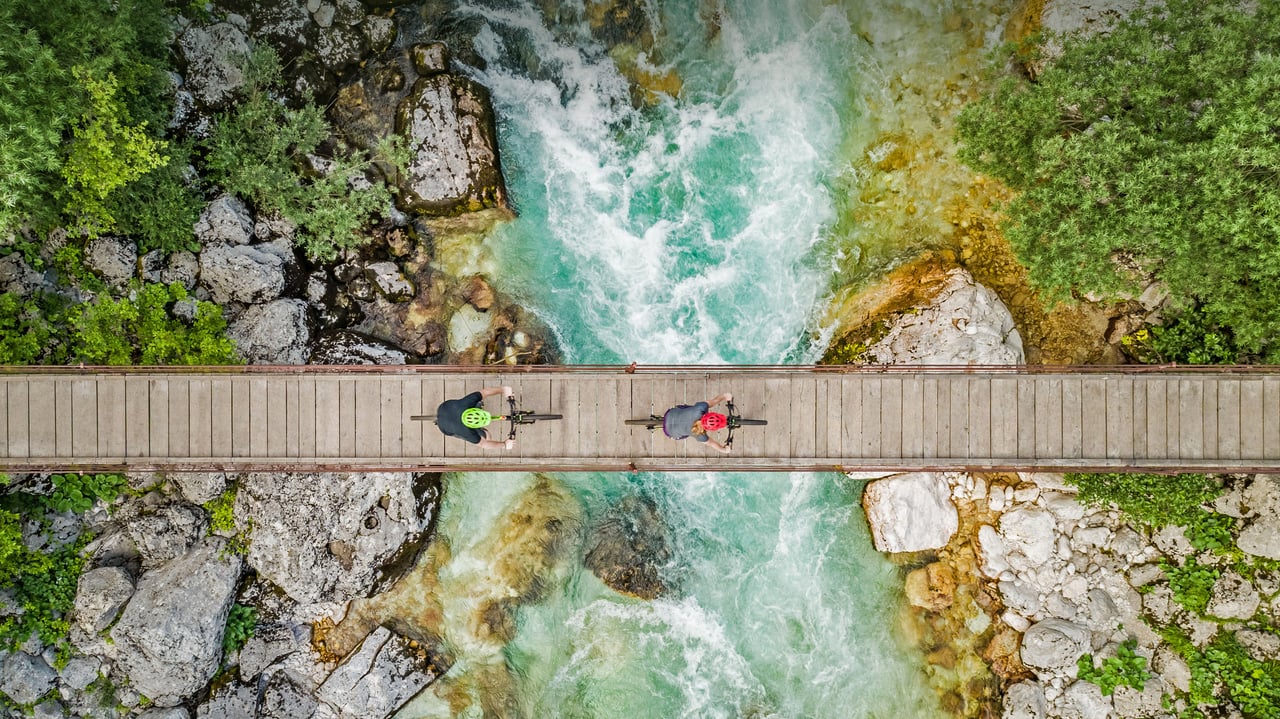 Cyclists on a wooden suspension bridge over the Soča River in Slovenia (© Amazing Aerial Agency/Offset by Shutterstock)