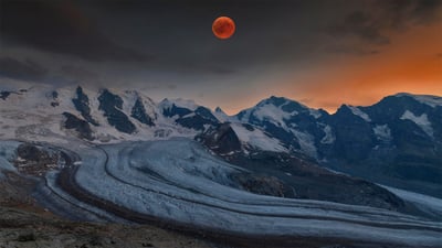 Bing wallpaper May 15, 2022. Panoramic view of the Bernina Range with blood moon, Eastern Alps, Engadin, Switzerland (© Bernd Zoller/Shutterstock)