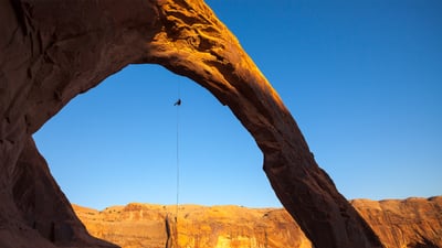 Bing wallpaper August 13, 2025. A man rappels off Corona Arch near Moab, Utah, United States (© Grant Ordelheide/TANDEM Stills + Motion)