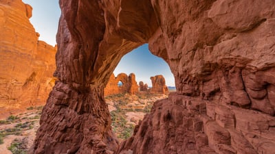 Bing wallpaper November 12, 2024. Double Arch seen through Cove Arch, Arches National Park, Utah (© Jeff Foott/Minden Pictures)