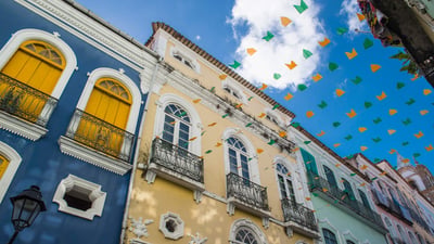 Bing wallpaper June 24, 2024. Rua em Salvador decorada com bandeiras coloridas entre prédios (© Henn Photography/Aurora Photos/Getty Images)