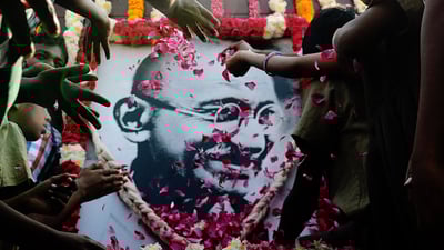Bing wallpaper January 29, 2021. School children pay homage to a portrait of Mahatma Gandhi on Martyr's Day. (© ARUN SANKAR/AFP via Getty Images)
