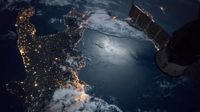 Bing wallpaper December 15, 2025. Volo della Stazione Spaziale sopra la punta meridionale dell'Italia (© NG Images/Alamy)