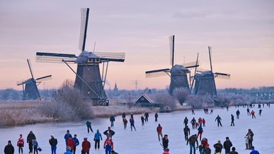 Bing wallpaper December 27, 2019. Skating on a frozen canal near the windmills at Kinderdijk, Netherlands (© Lourens Smak/Alamy)