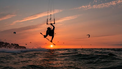 Bing wallpaper August 25, 2025. Silhouette eines springenden Kitesurfers bei Sonnenuntergang im baltischen Meer (© Jens Breuer/Getty Images)