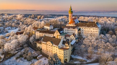 Bing wallpaper February 22, 2021. Winterliche Morgenstimmung am Kloster Andechs in Bayern mit Blick auf den Ammersee (© Reinhard Schmid/Huber/eStock Photo)