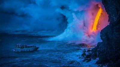 Bing wallpaper August 1, 2020. A lava flow hits water as a tour boat passes, Hawaii Volcanoes National Park (© Patrick Kelley/Getty Images)