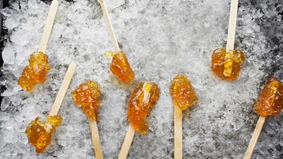 Bing wallpaper March 12, 2022. Hardened maple syrup on a wooden stick sitting on ice, Elmira, Ontario (© Design Pics/Offset/Shutterstock)