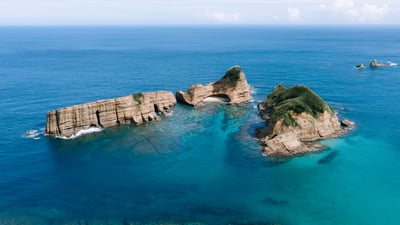 Bing wallpaper July 20, 2025. 青い海に浮かぶ種子島の無人島, 鹿児島県 (© Ippei Naoi/Getty Images)