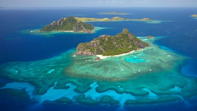 Bing wallpaper October 10, 2025. Coral reef surrounding the island of Monuriki, Mamanuca Islands, Fiji (© David Wall/SuperStock)