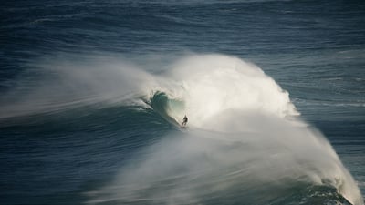 Bing wallpaper June 15, 2024. Surfer riding a wave in Nazaré, Portugal (© Rui Caria/Getty Images)