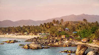 Bing wallpaper December 5, 2023. Beach with bungalow and coconut palm trees at Palolem in Goa, India. (© Pikoso.kz/Shutterstock)