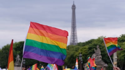 Bing wallpaper June 27, 2024. Drapeau arc-en-ciel brandi devant la tour Eiffel lors de la marche des fiertés (© Yuriko Nakao/Getty Images)
