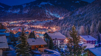 Bing wallpaper December 12, 2025. Vue sur un village de montagne illuminé, France (© Dario Berardi/500px)