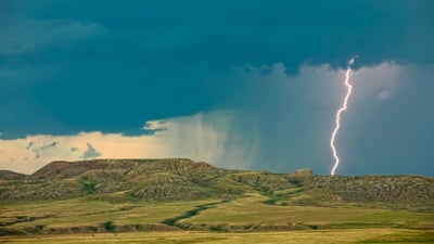 Bing wallpaper March 28, 2021. Lightning striking over 70 Mile Butte and Sleeping Lion Butte, Grasslands National Park, Saskatchewan (© Design Pics/DanitaDelimont.com)